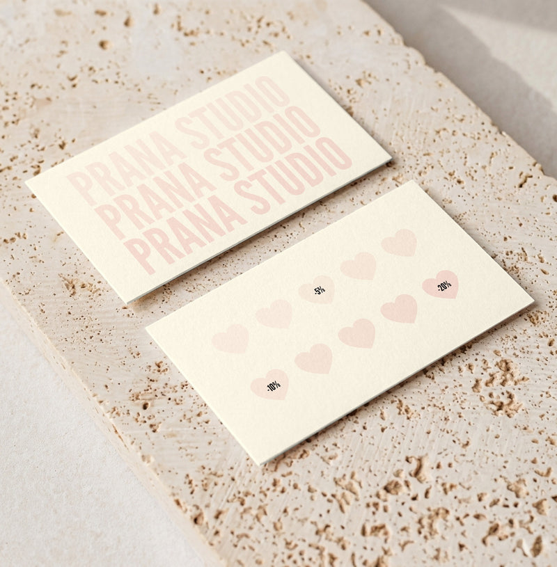 Editable loyalty card template for beauty professionals, Cream & Blush · Hearts design, front and back shown on travertine